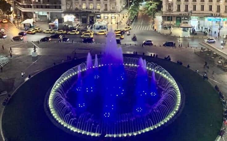 Omonia Square fountain illuminated in blue and white