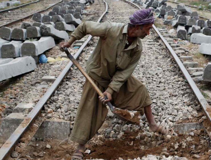 A Pakistani laborer digs in preparation for the replacement of concrete sleepers along a railway track in Karachi in Jan. 2018. © Reuters