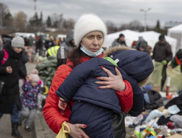 Ukraine Greece A woman carries her child as she arrives at the Medyka border crossing after fleeing from the Ukraine, in Poland, Monday. [AP]