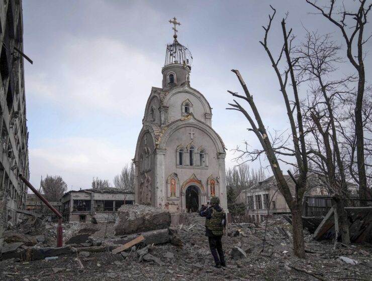 An Ukrainian soldier takes a photograph of a damaged church after shelling in a residential district in Mariupol, Ukraine, March 10, 2022. (AP Photo) Dendias