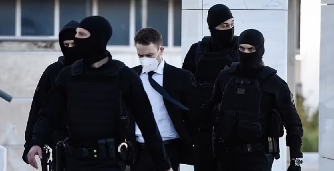 Flanked by cops, Babis Anagnostopoulos (centre) wore a bulletproof vest to court on April 8, 2022.