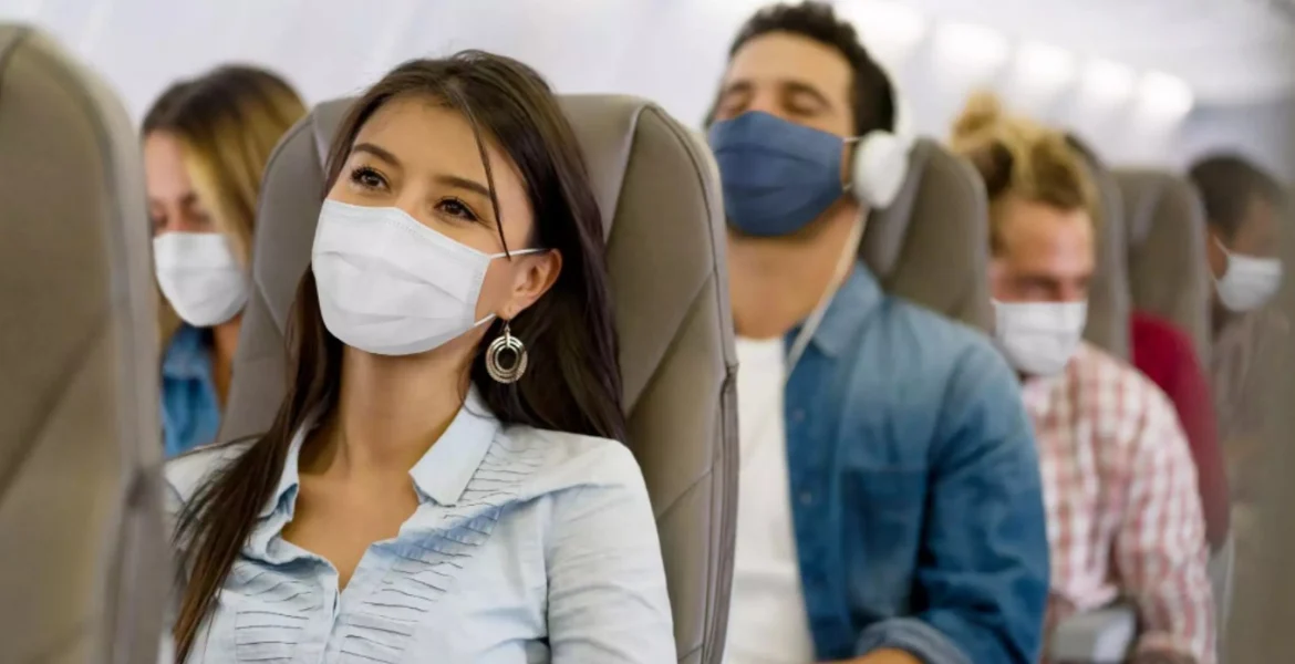 Travelers wearing masks on a plane | CREDIT: GETTY