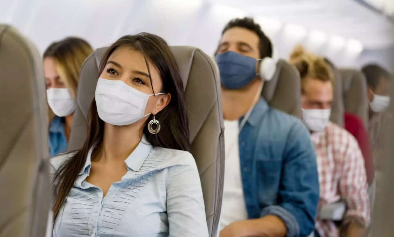 Travelers wearing masks on a plane | CREDIT: GETTY