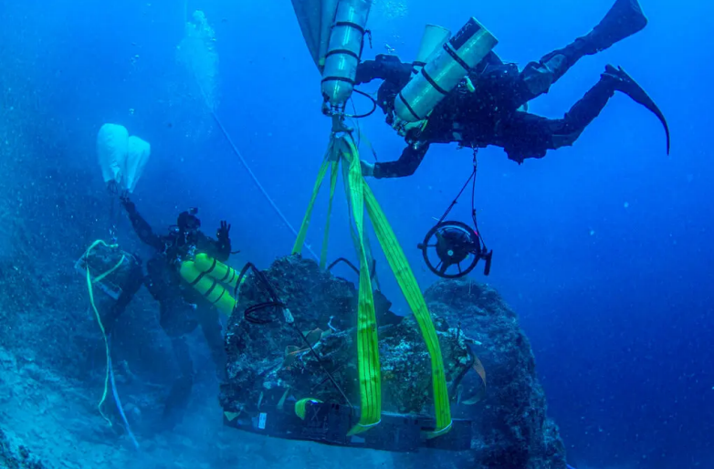 Divers in Greece hoisting items from the shipwreck, whose remains included a marble head believed to be a representation of Hercules, the mythological hero of ancient Rome and Greece. Nikos Giannoulakis/Swiss School of Archaeology in Greece/Hellenic Ministry of Culture and Sports
