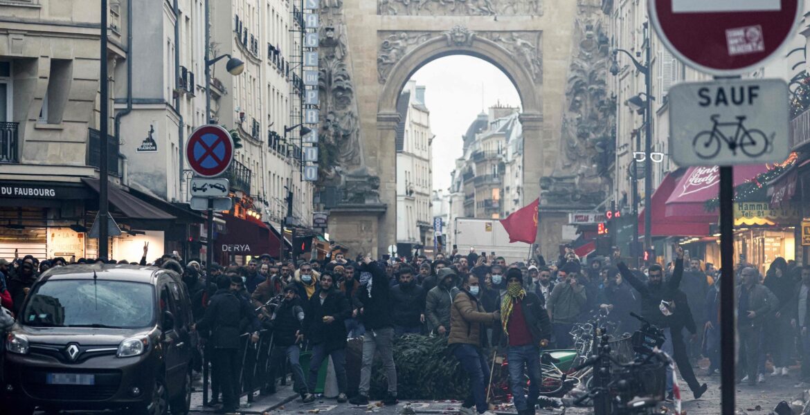 Protestors stand in front of riot police Kurdish officers following a statement by French Interior Minister Gerald Darmanin (unseen) at the site where several shots were fired along rue d'Enghien in the 10th arrondissement, in Paris on Dec. 23, 2022. (AFP Photo)
