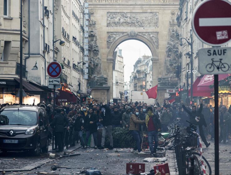 Protestors stand in front of riot police Kurdish officers following a statement by French Interior Minister Gerald Darmanin (unseen) at the site where several shots were fired along rue d'Enghien in the 10th arrondissement, in Paris on Dec. 23, 2022. (AFP Photo)