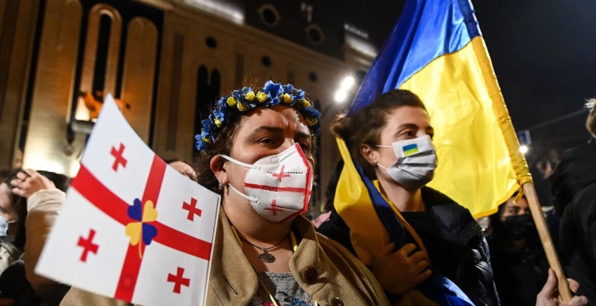 Ukraine Demonstrators hold placards and wave flags during a rally in support of Ukraine in Tbilisi, Georgia, on March 1, 2022. VANO SHLAMOV/AFP/GETTY IMAGES