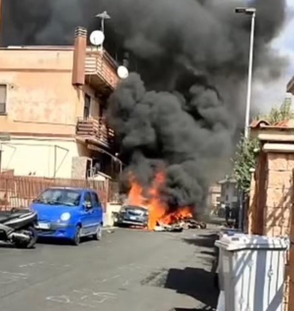 Pictured: A flaming car and one of the plane wrecks is seen in the town of Guidonia.