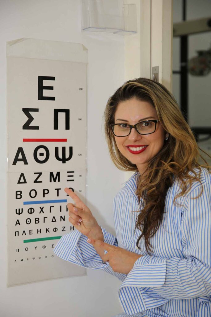 Liberal Candidate for Newtown, Ms Fiona Douskou, is pointing at Greek Letters on an eye chart at a local Greek Optometrist in Marrickville, Sydney, called GT Optica.