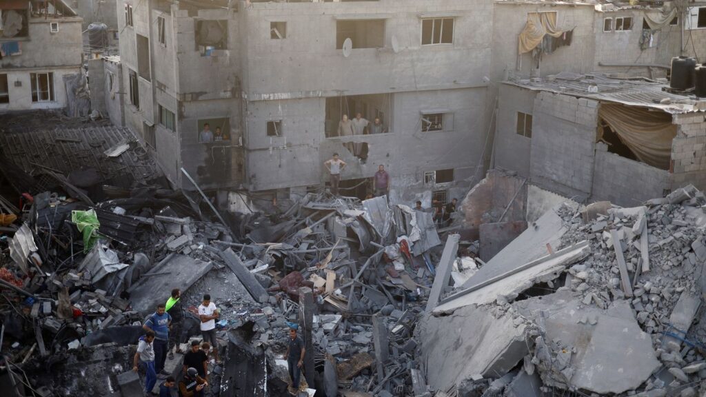 Palestinians search for casualties at the site of a blast at Maghazi refugee camp