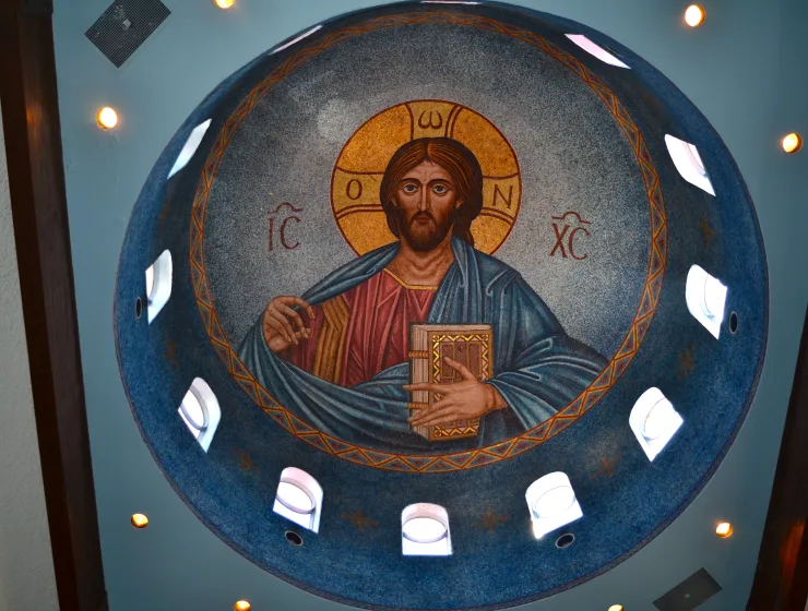 This is an image of Christ as Pantocrator in the Byzantine mosaic style, characteristic of Eastern Orthodox Religious art iconography. The IC and the XC are abbreviations for the Greek word meaning “Jesus Christ”. In his left hand, Jesus holds the New Testament and the gesture of his right hand indicates a blessing.