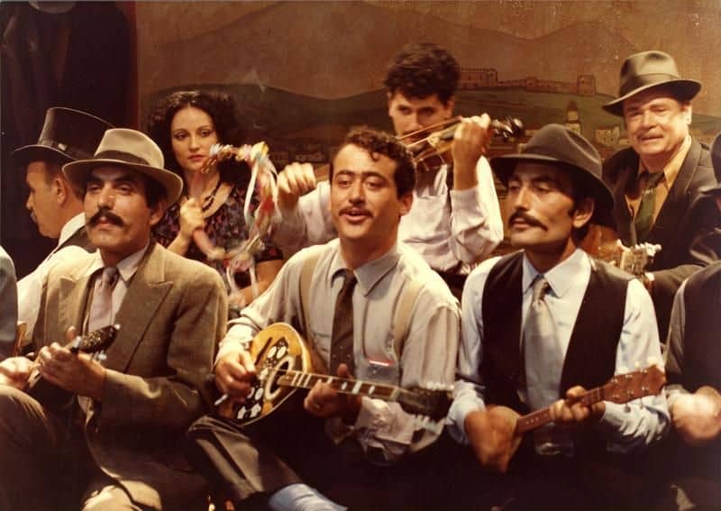 Rebetiko musicians playing bouzouki in a taverna