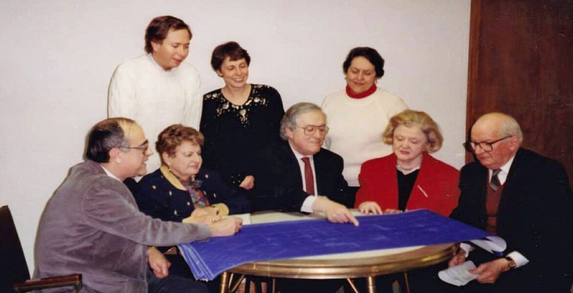 Image of several gathered around a table looking at blueprints