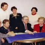Image of several gathered around a table looking at blueprints