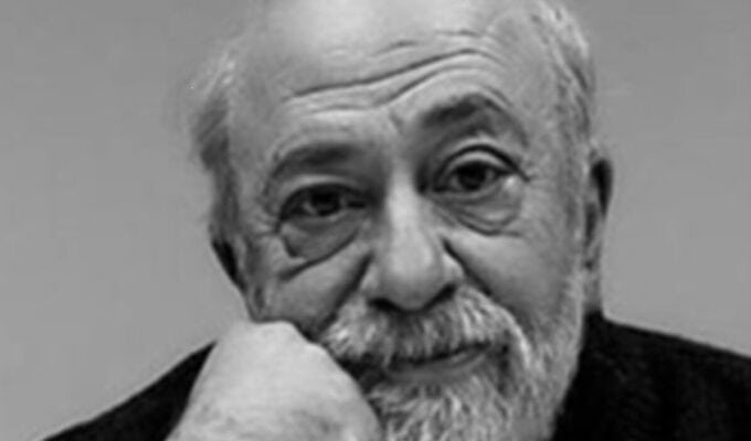 Master Filmmaker Pantelis Voulgaris. B&W image of a bald man with a gray beard wearing a black sweater