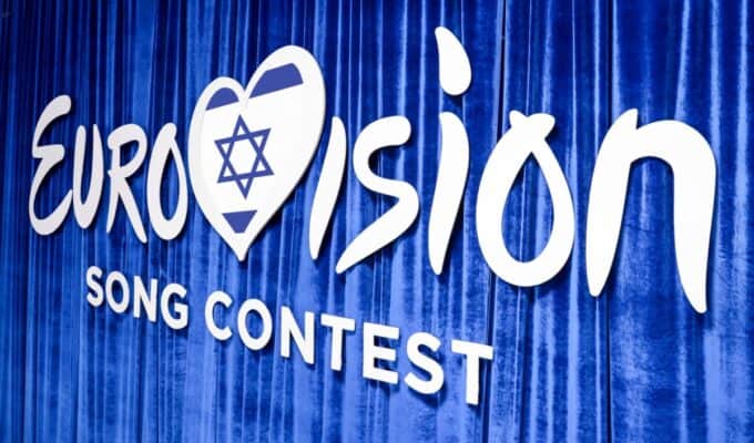 Eurovision Song Contest 2023 sign on blue curtain backdrop, highlighting Greece's participation and support for Greece's entry in the international music competition.