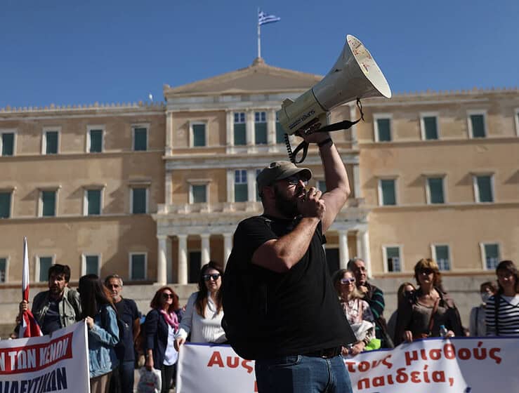 Communist anarchist protester holding a megaphone in front of the Greek Parliament building during a demonstration in Athens Greece Greek City Times.