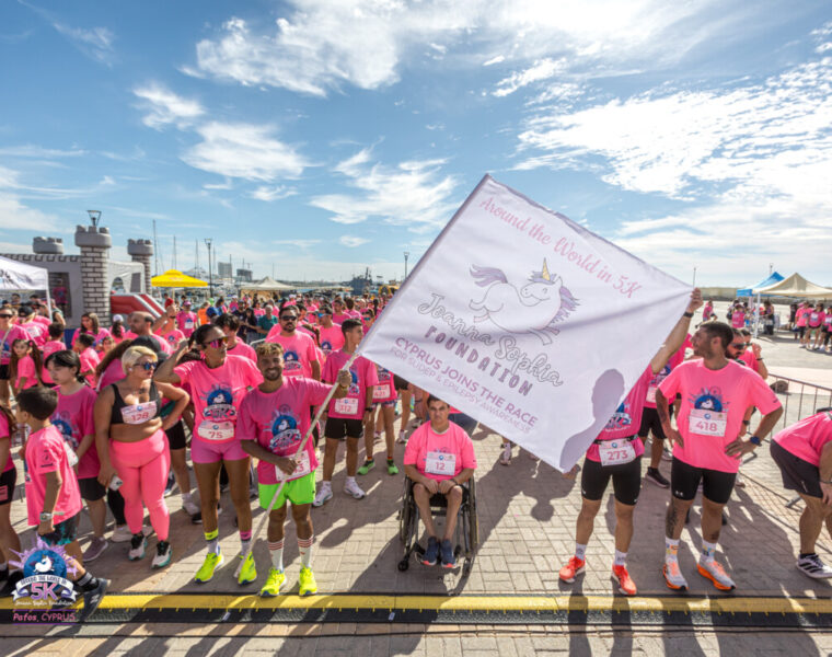 Starting line at Joanna Sophia Foundation Fun Run/Walk. Image of people in pink tshirts holding a flag
